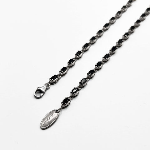 Silver  bracelet with black stones on it.